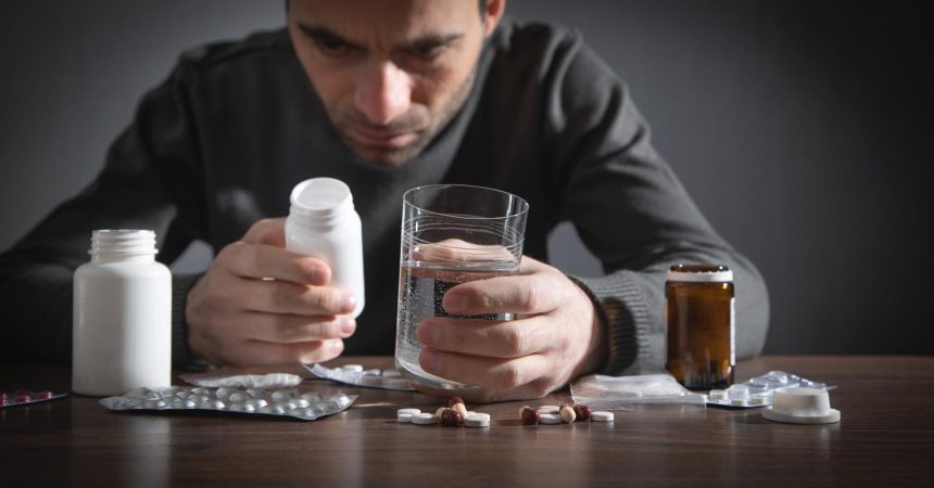 Caucasian depressed man with a pills.